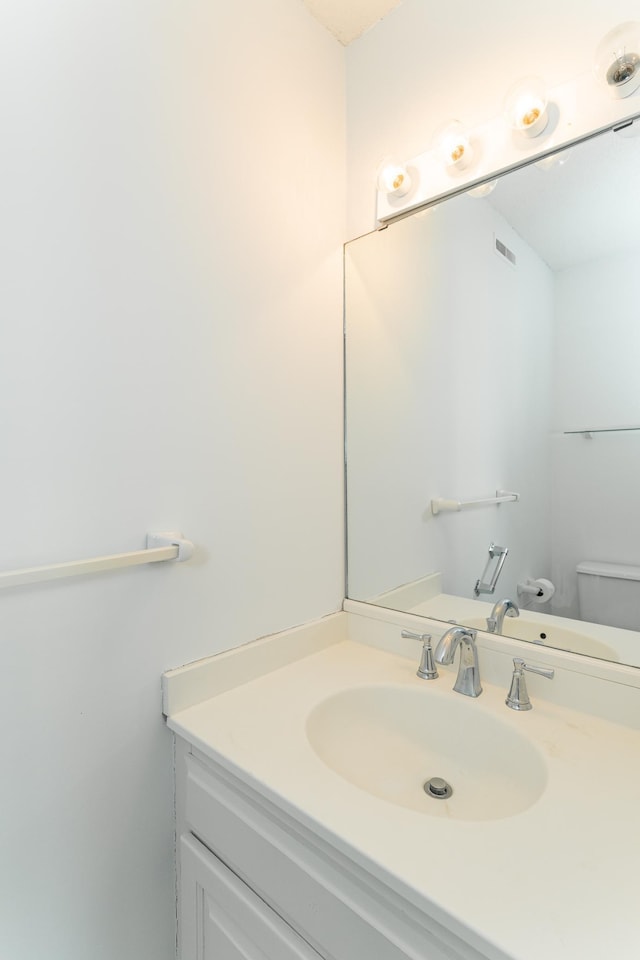 bathroom featuring vanity and toilet