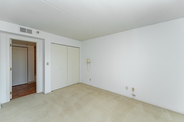 unfurnished bedroom featuring carpet flooring and a closet