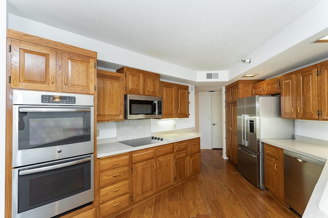 600 4th St SW Unit 308, Rochester, MN 55902 - kitchen featuring stainless steel appliances, wood finished floors, light countertops, brown cabinets, and a textured ceiling