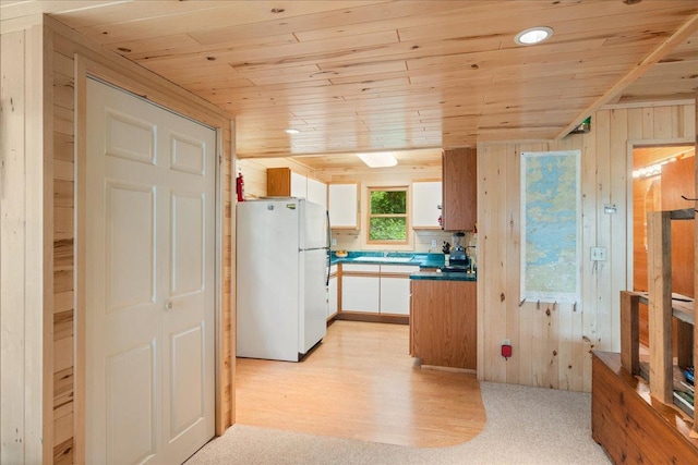 95536 Pine Is, Greenwood Twp, MN 55790 - kitchen with freestanding refrigerator, wooden ceiling, white cabinets, dark countertops, and wood walls
