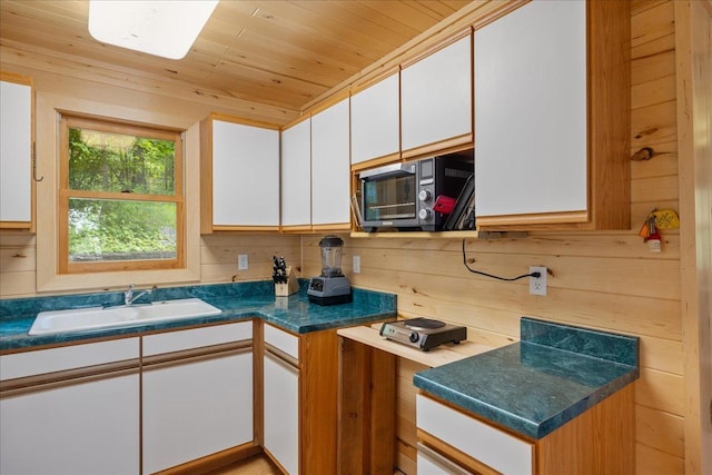 95536 Pine Is, Greenwood Twp, MN 55790 - kitchen with a sink, wooden ceiling, white cabinets, stainless steel microwave, and wooden walls