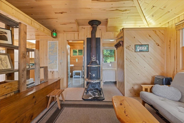 95536 Pine Is, Greenwood Twp, MN 55790 - living area with a wood stove, wood ceiling, wood walls, and carpet floors