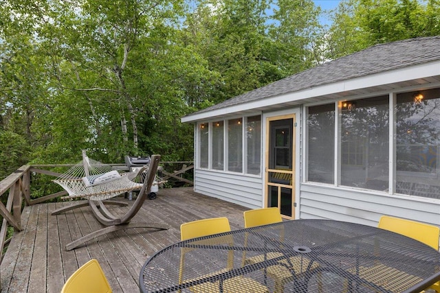95536 Pine Is, Greenwood Twp, MN 55790 - deck featuring outdoor dining area, a sunroom, and view of wooded area