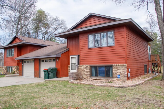 view of front of house featuring an attached garage, driveway, and a front yard