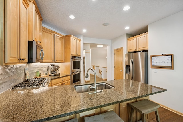 17300 Tilia Rdg, Eden Prairie, MN 55347 - kitchen featuring a sink, stainless steel appliances, a peninsula, a breakfast bar, and dark wood finished floors