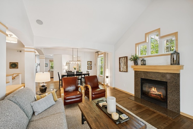 17300 Tilia Rdg, Eden Prairie, MN 55347 - living area with high vaulted ceiling, wood finished floors, arched walkways, a premium fireplace, and decorative columns