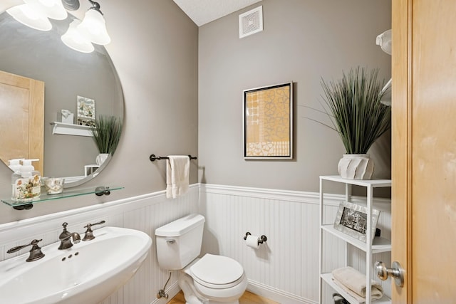 17300 Tilia Rdg, Eden Prairie, MN 55347 - half bathroom featuring a sink, wainscoting, and toilet