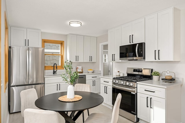 4836 Bloomington Ave, Minneapolis, MN 55417 - kitchen with appliances with stainless steel finishes, a sink, light countertops, and white cabinets