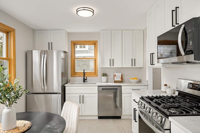 4836 Bloomington Ave, Minneapolis, MN 55417 - kitchen featuring appliances with stainless steel finishes, a sink, healthy amount of natural light, and white cabinets