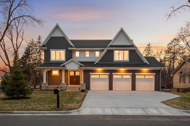 craftsman-style house with driveway, roof with shingles, a lawn, and a garage