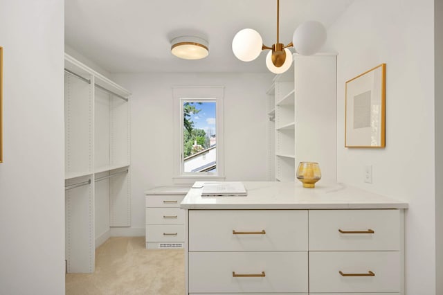 walk in closet with light carpet