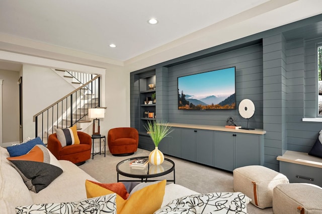 living area with recessed lighting, stairs, and light carpet