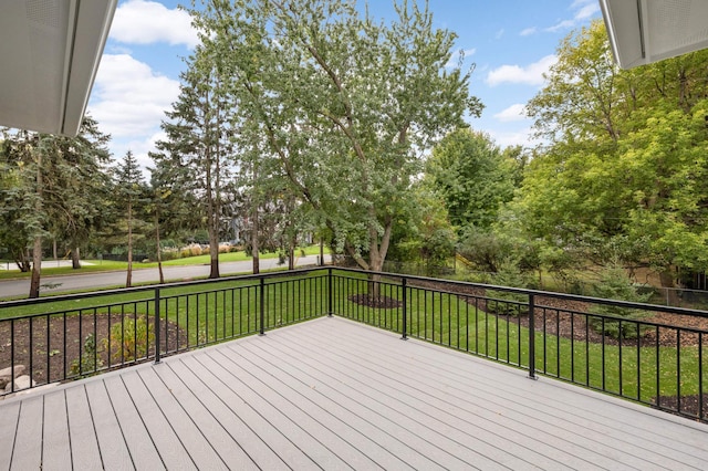 wooden deck featuring a lawn