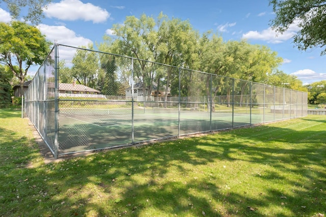 view of sport court with a yard and fence