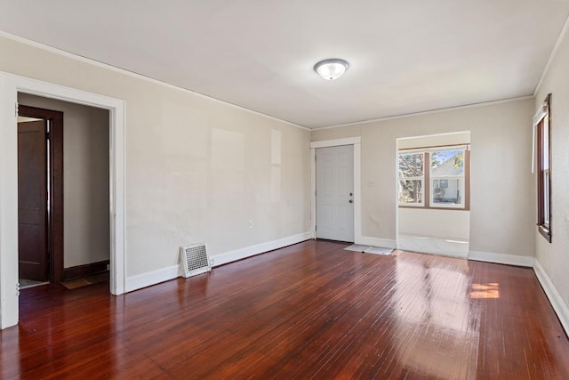 spare room with visible vents, baseboards, ornamental molding, and wood-type flooring