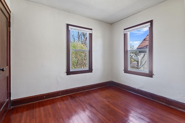 spare room with wood-type flooring and baseboards