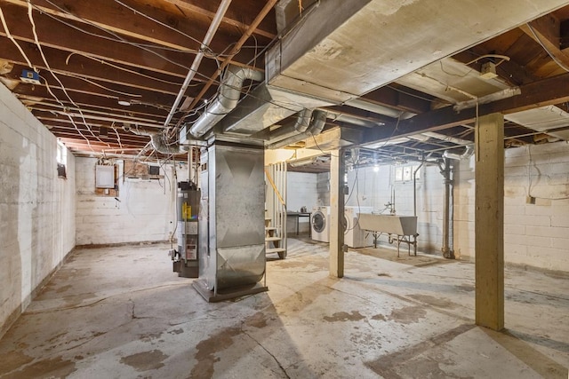 unfinished basement featuring gas water heater, a sink, and washing machine and clothes dryer