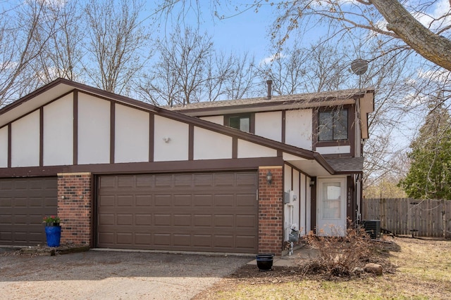 view of front of house with fence, central AC, stucco siding, and brick siding