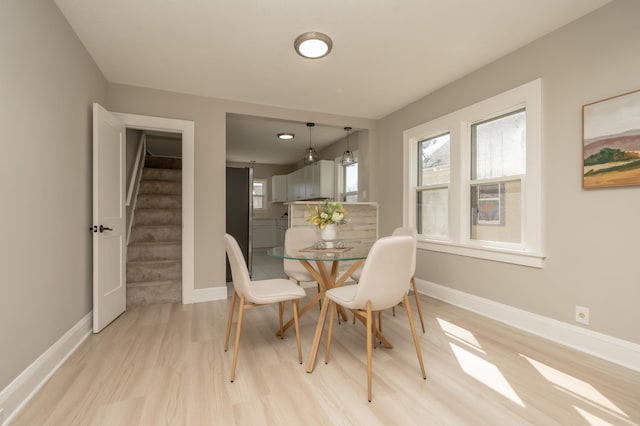 1634 Upton Ave N, Minneapolis, MN 55411 - dining space featuring light wood-type flooring, stairs, and baseboards