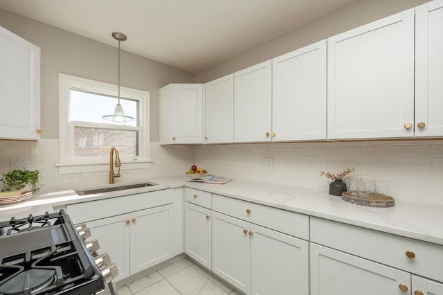 1634 Upton Ave N, Minneapolis, MN 55411 - kitchen with gas stove, a sink, white cabinets, backsplash, and pendant lighting