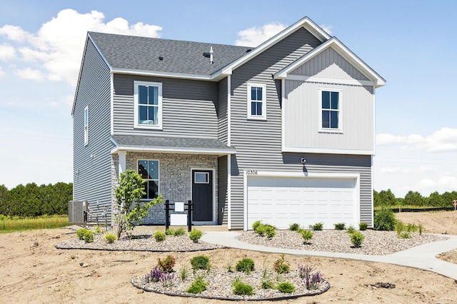 view of front of house featuring stone siding, central AC, and an attached garage