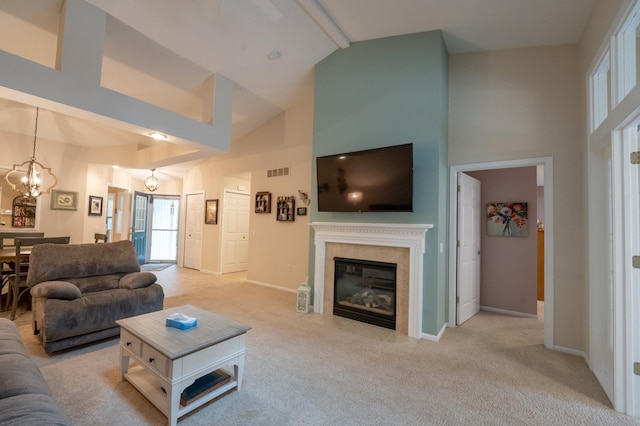 living area with a glass covered fireplace, high vaulted ceiling, light carpet, and visible vents