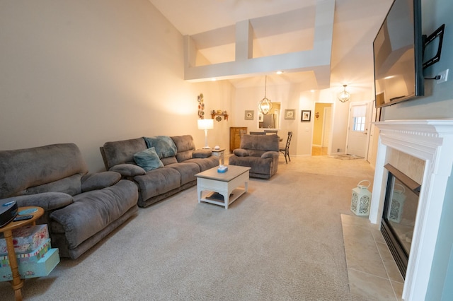 living room featuring a tile fireplace, high vaulted ceiling, and light colored carpet