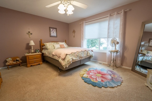 bedroom with visible vents, ceiling fan, light carpet, and baseboards