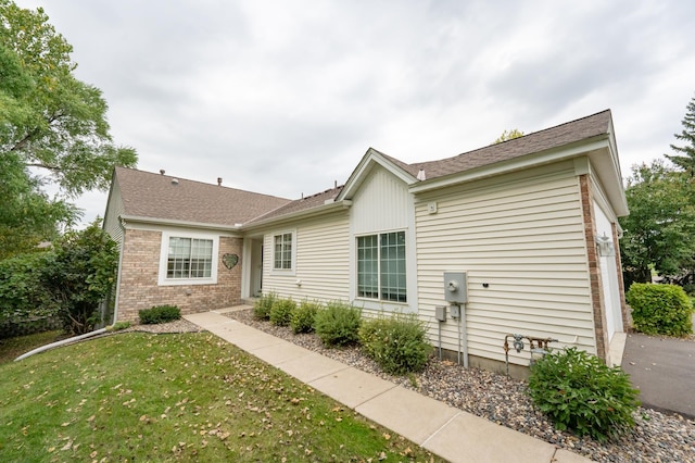 view of front facade featuring brick siding and a front yard
