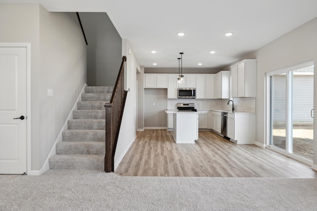 kitchen with baseboards, appliances with stainless steel finishes, and white cabinetry