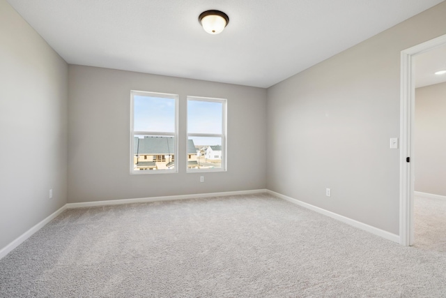 empty room featuring carpet flooring and baseboards
