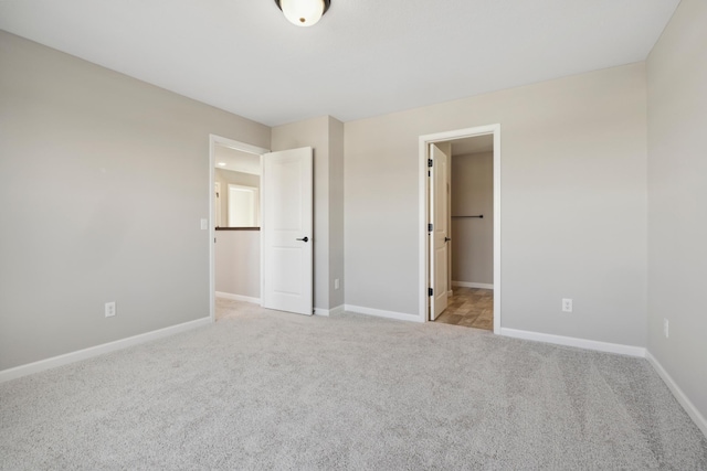 unfurnished bedroom with light carpet and baseboards