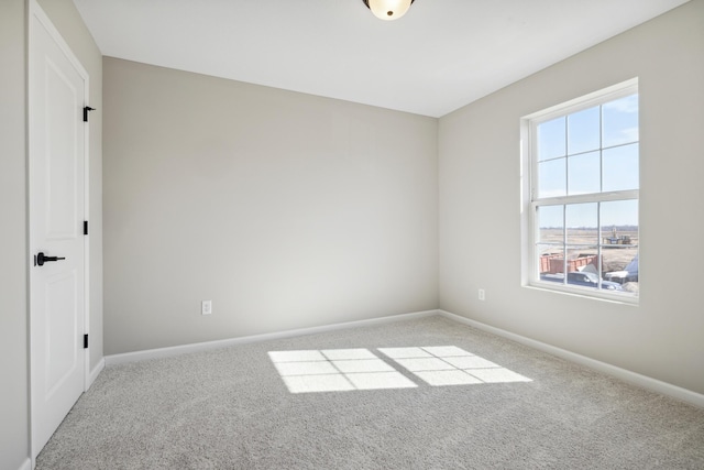 empty room featuring carpet and baseboards