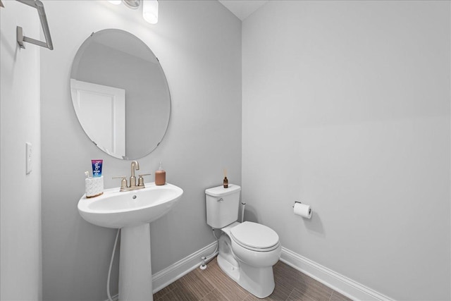 bathroom featuring a sink, toilet, and baseboards