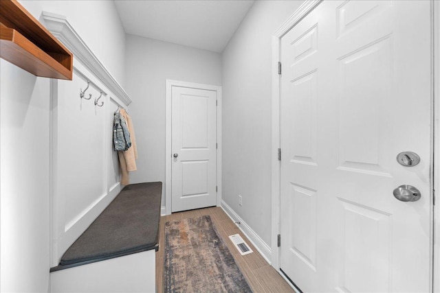 mudroom featuring visible vents, baseboards, and dark wood-type flooring