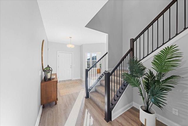 stairway with wood finished floors and baseboards