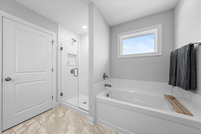 full bathroom featuring a shower stall and a garden tub