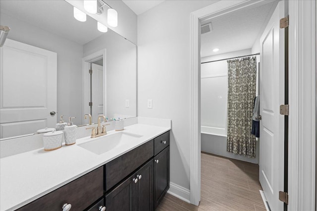 full bath featuring visible vents, vanity, shower / bath combination with curtain, and baseboards