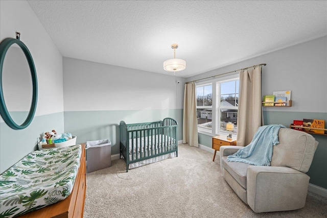 bedroom with carpet, baseboards, and a textured ceiling