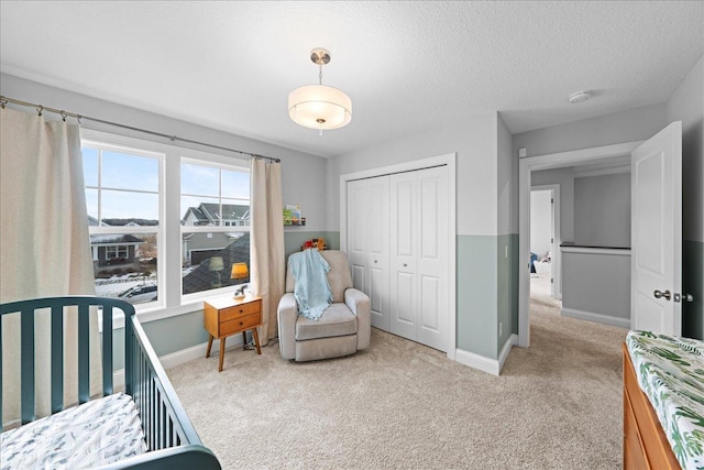 carpeted bedroom with a closet, a textured ceiling, and baseboards