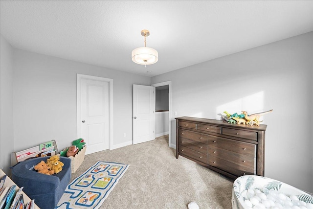 bedroom with light colored carpet and baseboards