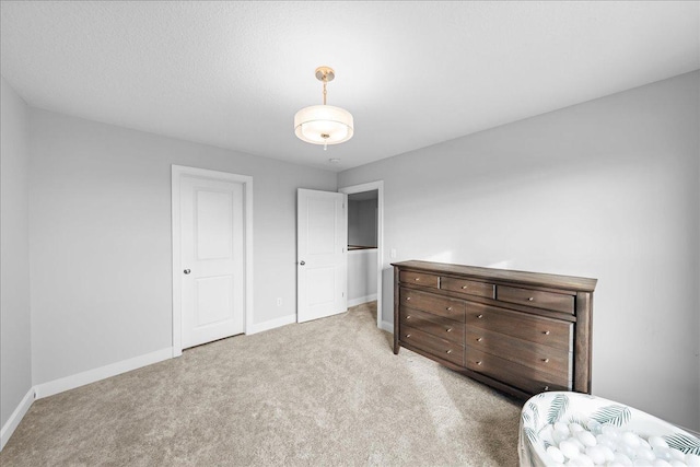 bedroom featuring baseboards and light colored carpet