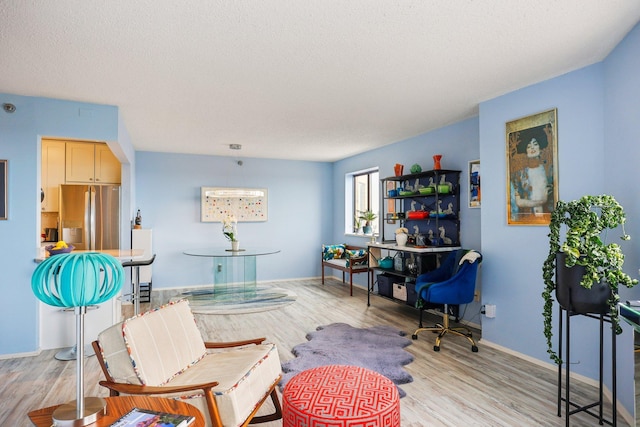 living area featuring baseboards and light wood-type flooring