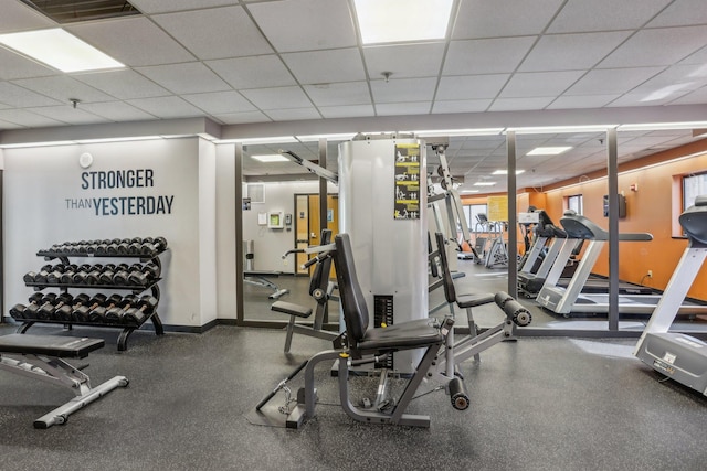 workout area featuring baseboards, a drop ceiling, and visible vents