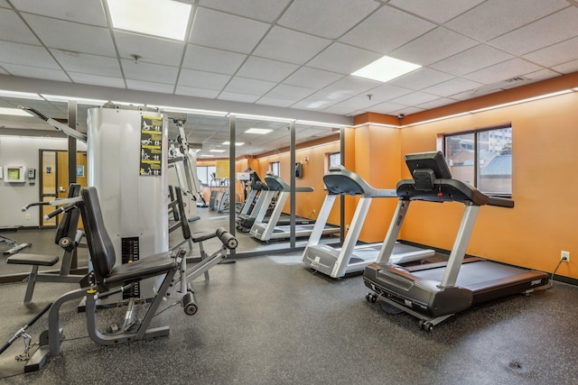 gym with a drop ceiling and a wealth of natural light