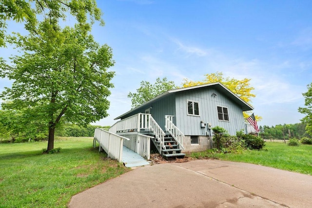 25431 Larch St NW, Isanti, MN 55040 - view of side of property with board and batten siding, a lawn, and stairway