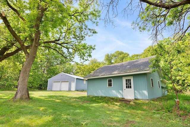 25431 Larch St NW, Isanti, MN 55040 - rear view of house with a garage, an outdoor structure, a yard, and a shingled roof