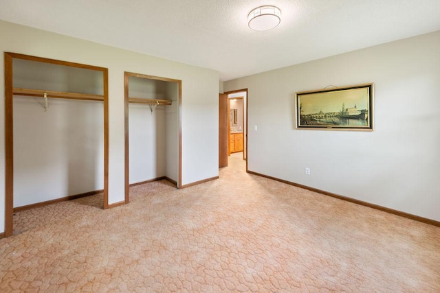25431 Larch St NW, Isanti, MN 55040 - unfurnished bedroom with multiple closets, light carpet, and a textured ceiling