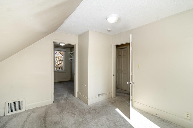 1040 26th Ave SE, Minneapolis, MN 55414 - additional living space featuring lofted ceiling, a textured ceiling, visible vents, baseboards, and carpet floors
