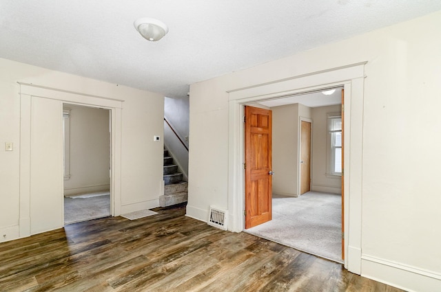 1040 26th Ave SE, Minneapolis, MN 55414 - spare room with baseboards, visible vents, wood finished floors, and stairs